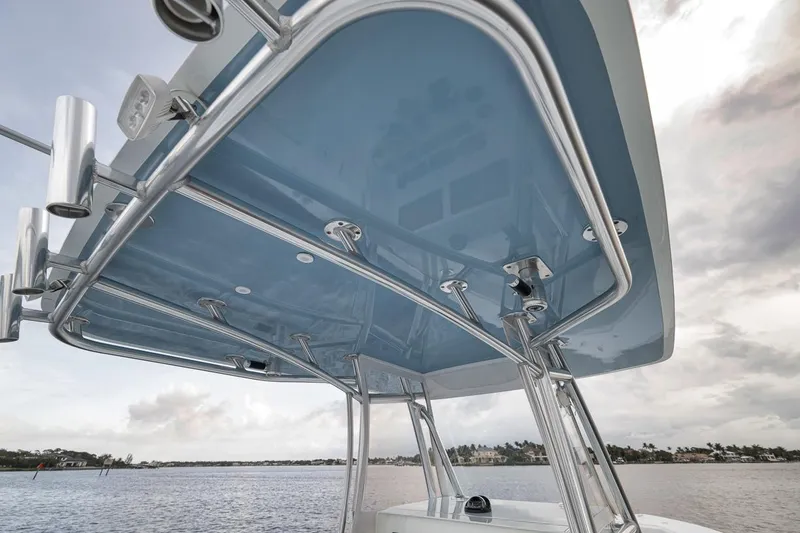 Slide: The Image of 2019 Contender 32 ST boat T-top with rod holders, viewed from below on a cloudy day. - 71