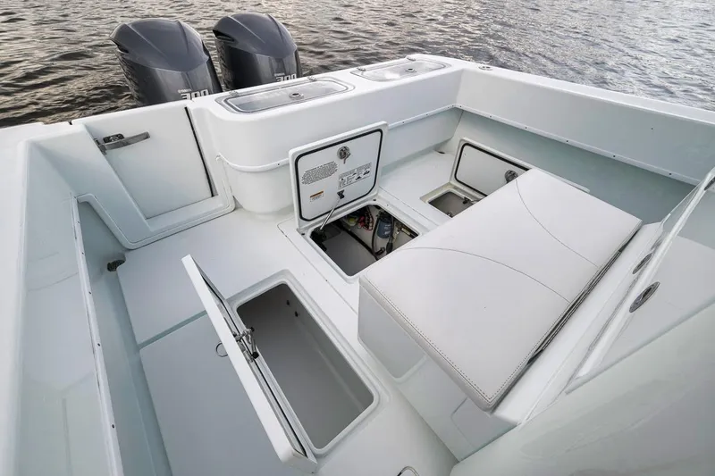 Slide: The Image of 2019 Contender 32 ST boat interior with storage compartments and twin engines on water. - 72