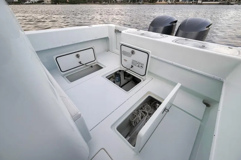 Slide: The Image of 2019 Contender 32 ST boat deck with open storage compartments and twin engines. - 73