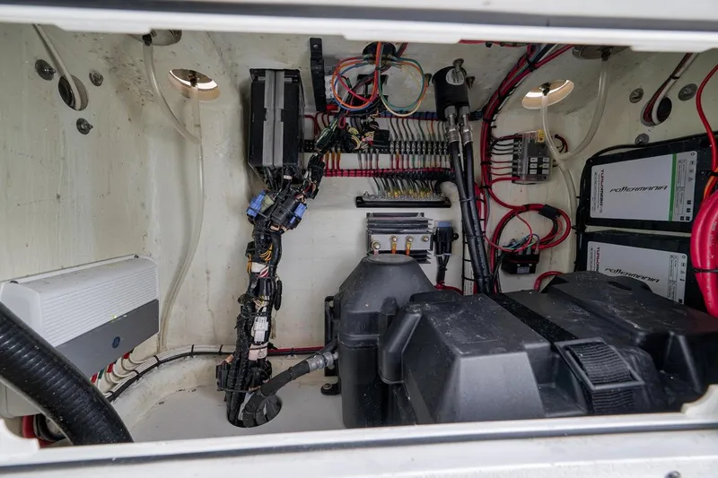 Slide: The Image of Electrical compartment of a 2019 Contender 32 ST boat, showcasing wiring and components. - 77