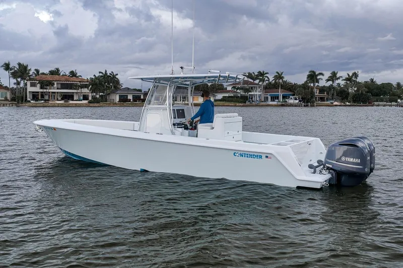 Slide: The Image of 2019 Contender 32 ST boat on water, featuring Yamaha engines, with waterfront homes in the background. - 8