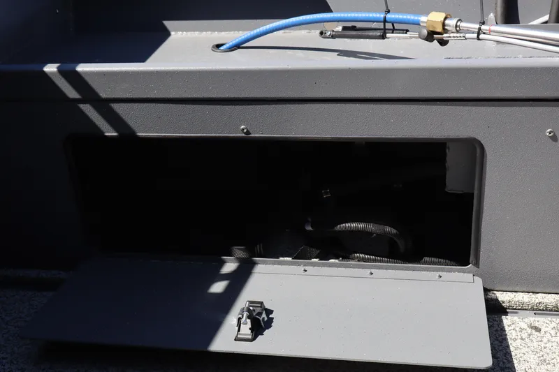 Slide: The Image of Open storage compartment on 2026 Alumaweld Talon 18 boat with visible hose. - 12