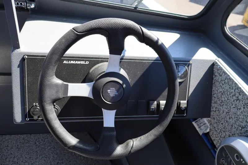 Slide: The Image of Steering wheel of 2026 Alumaweld Talon 18 boat, featuring modern dashboard controls. - 17