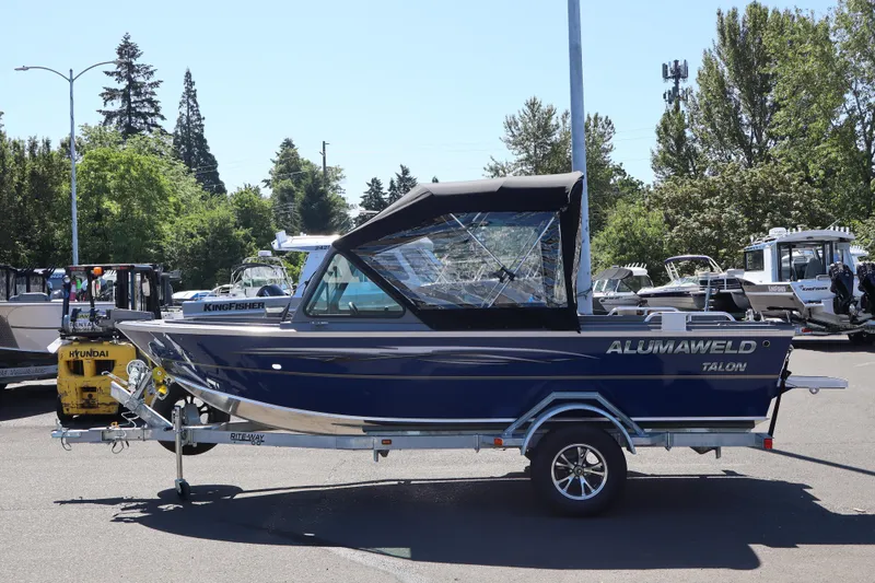Slide: The Image of 2026 Alumaweld Talon 18 boat on trailer, parked outdoors in a sunny setting. - 4