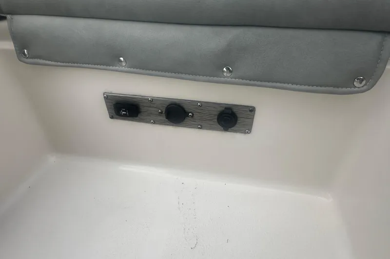 Slide: The Image of 2024 Carolina Skiff 21 Ultra Elite interior panel with switches and gray upholstery. - 11