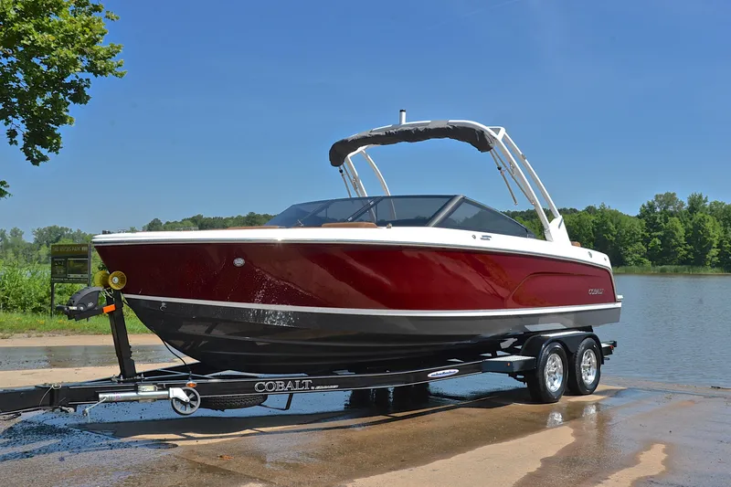 Slide: The Image of 2024 Cobalt CS23 boat on trailer by a lake, sunny day. - 11
