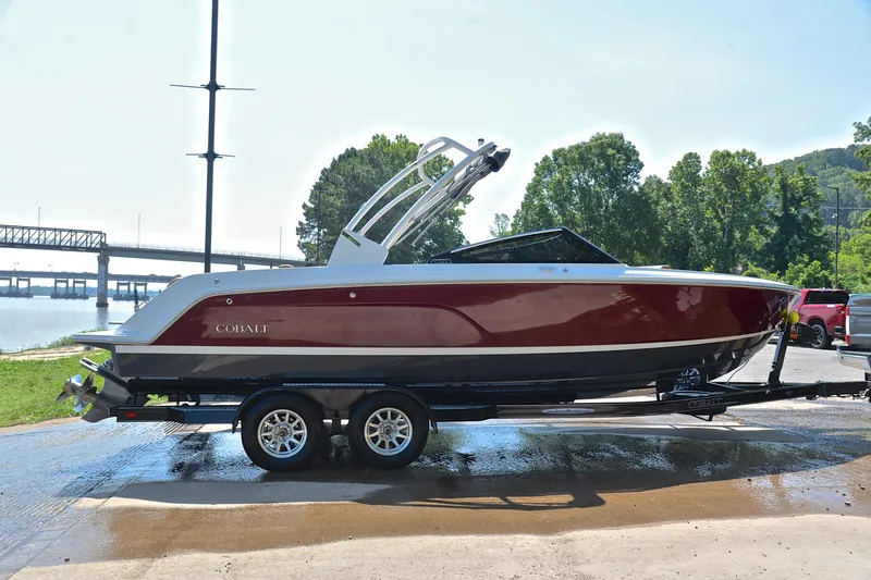 Slide: The Image of 2024 Cobalt CS23 boat on trailer by riverside, showcasing sleek design and vibrant color. - 16