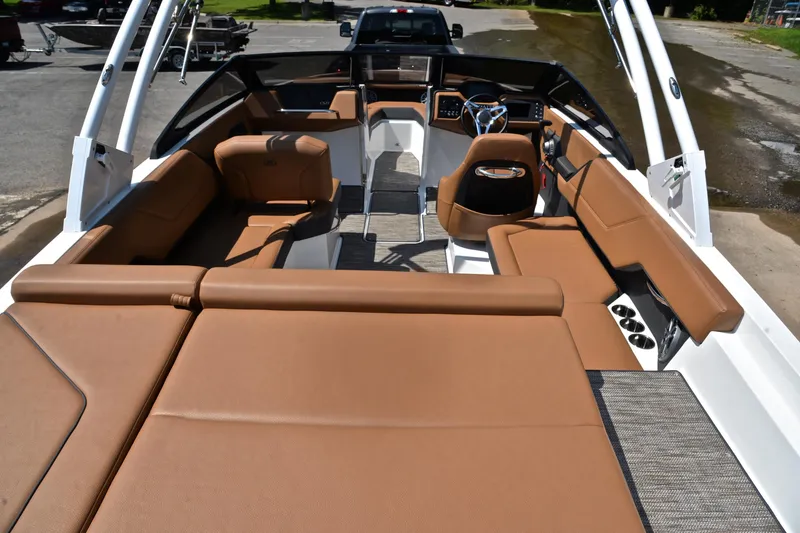 Slide: The Image of 2024 Cobalt CS23 boat interior with luxurious brown seating and modern dashboard. - 19