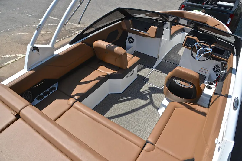 Slide: The Image of 2024 Cobalt CS23 boat interior with brown seating and modern dashboard design. - 20