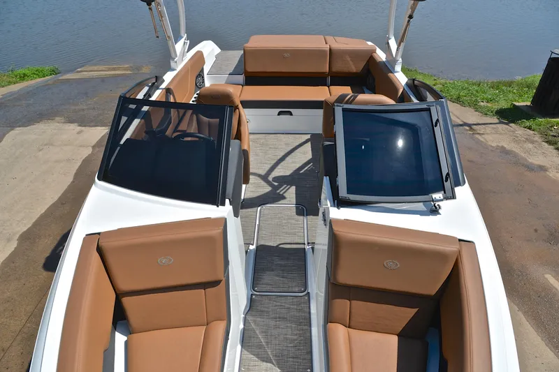 Slide: The Image of 2024 Cobalt CS23 boat interior with tan seating and sleek design by the water. - 21