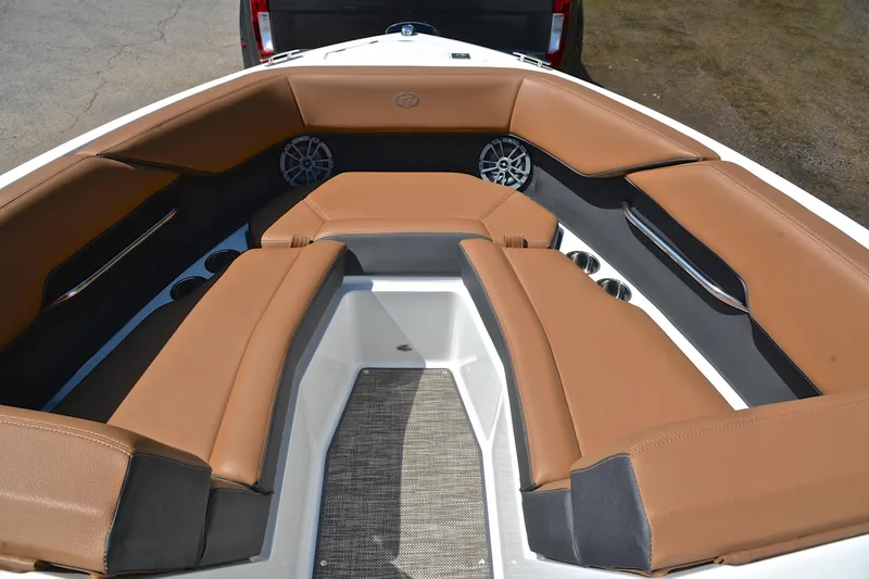 Slide: The Image of 2024 Cobalt CS23 boat interior with brown leather seating and built-in speakers. - 22