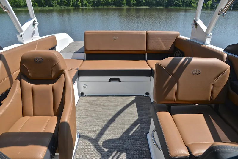 Slide: The Image of Luxurious interior of 2024 Cobalt CS23 boat with brown leather seating by a lake. - 23