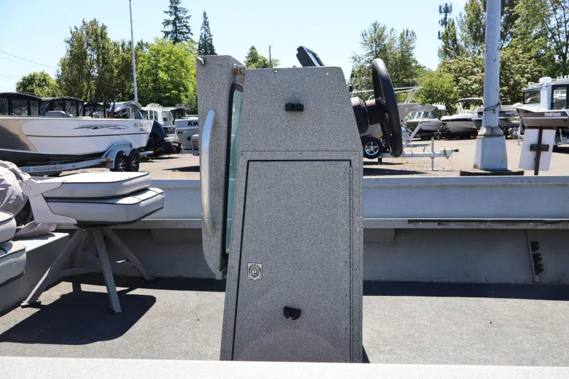 Slide: The Image of 2003 Alumaweld Flatbottom boat interior with steering console and seating, parked outdoors. - 10