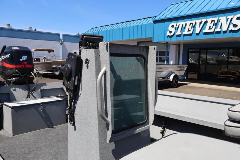 Slide: The Image of 2003 Alumaweld Flatbottom boat at dealership, featuring Mercury 90 engine. - 16