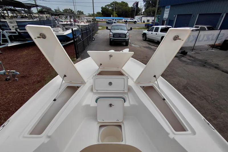 Slide: The Image of 2018 Key West 230 Bay Reef boat with open storage compartments, parked outdoors. - 16