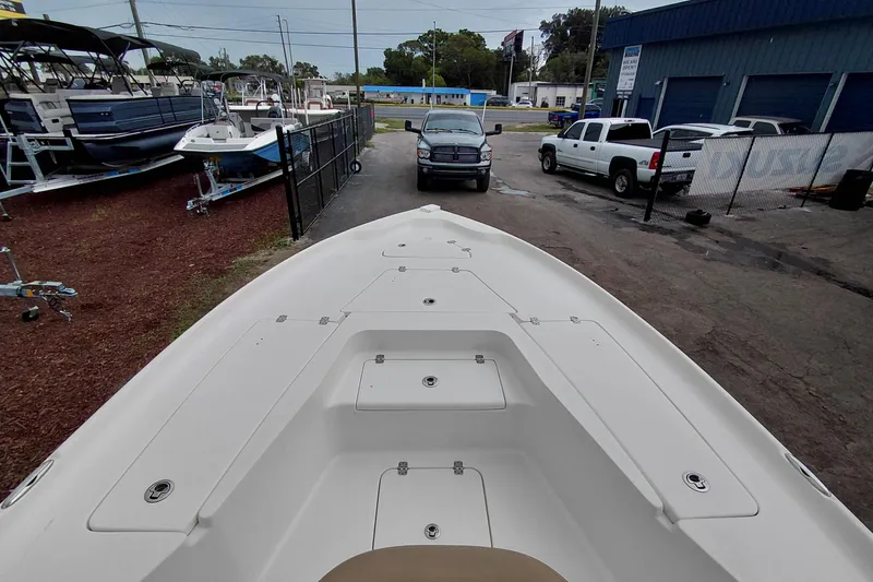 Slide: The Image of 2018 Key West 230 Bay Reef boat in a dealership lot with trucks nearby. - 17