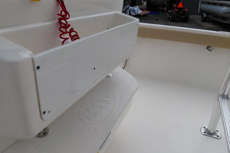 Slide: The Image of Interior view of a 2018 Key West 230 Bay Reef boat, featuring storage compartment and KW logo. - 31