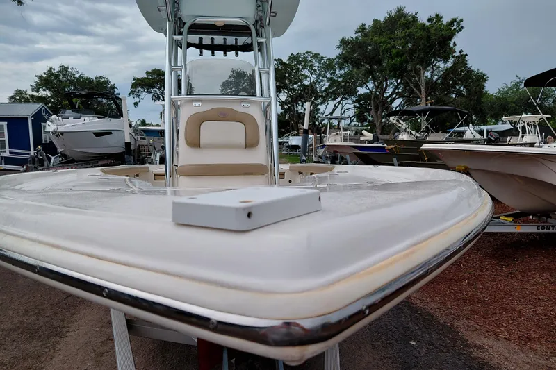 Slide: The Image of 2018 Key West 230 Bay Reef boat on display at a marina, surrounded by trees and other boats. - 53