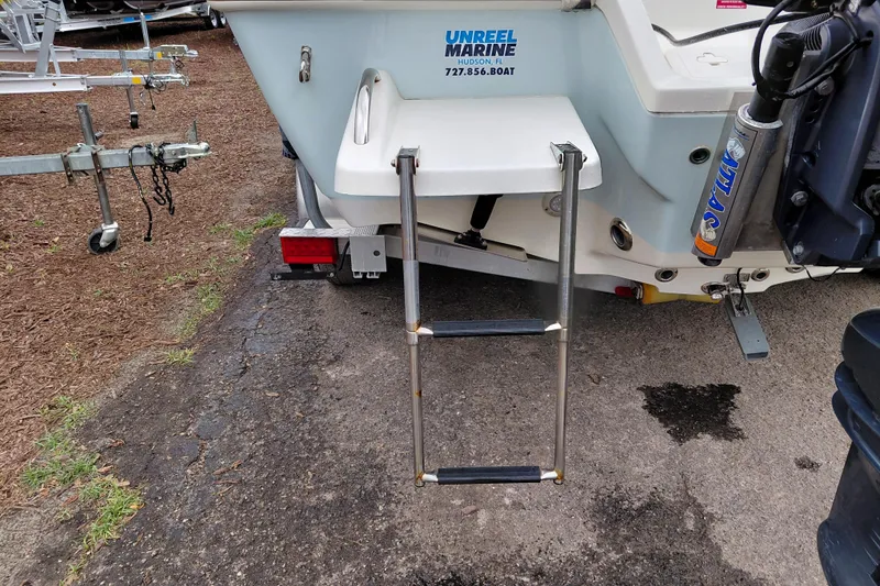 Slide: The Image of 2018 Key West 230 Bay Reef boat with ladder and motor, parked on pavement. - 57