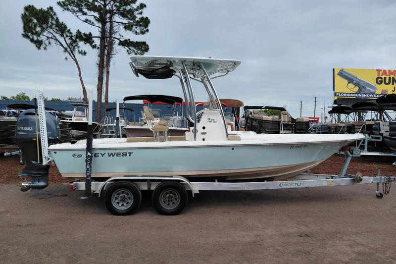 Slide: The Image of 2018 Key West 230 Bay Reef boat on trailer, parked outdoors near trees. - 8