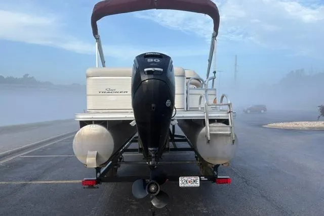 Slide: The Image of 2010 Sun Tracker Party Barge 21 Signature Series on trailer, rear view with outboard motor. - 21