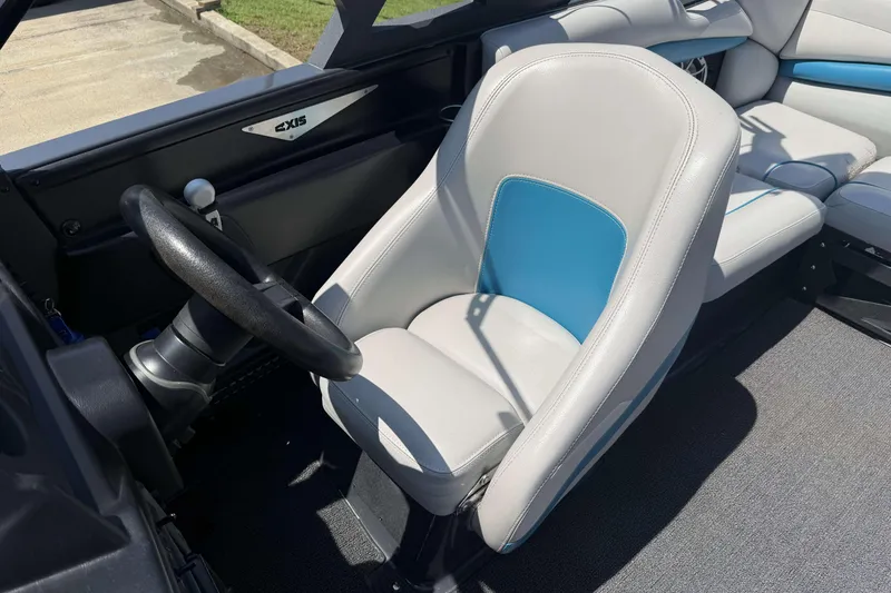 Slide: The Image of 2016 Axis A22 boat interior with steering wheel and white-blue captain's seat. - 10