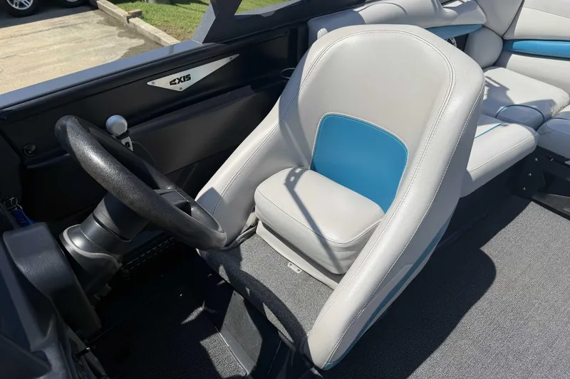 Slide: The Image of 2016 Axis A22 boat interior with steering wheel and gray-blue seating. - 11