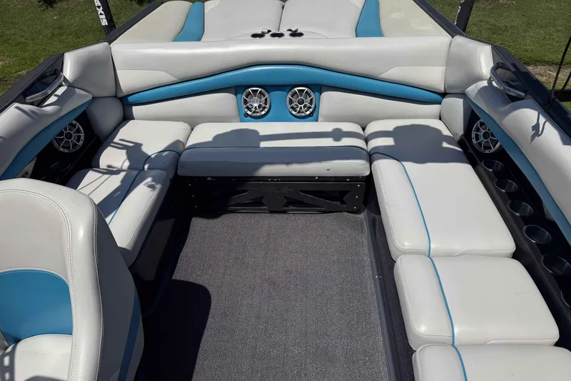 Slide: The Image of 2016 Axis A22 boat interior with white and blue seating, featuring built-in speakers. - 24