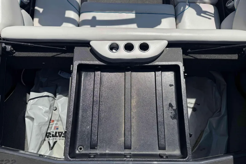 Slide: The Image of 2016 Axis A22 boat interior with storage compartment and cup holders. - 26