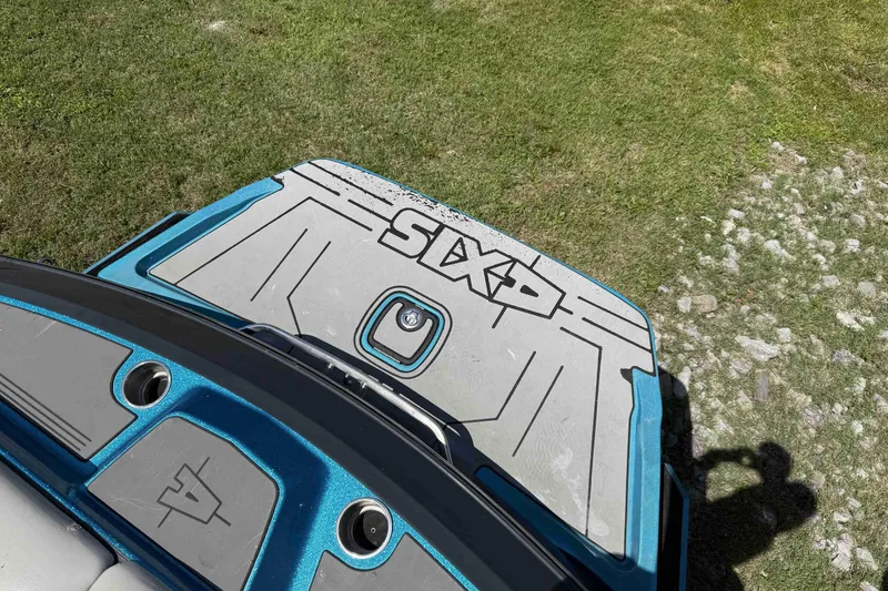 Slide: The Image of 2016 Axis A22 boat deck with blue accents on grassy terrain. - 32