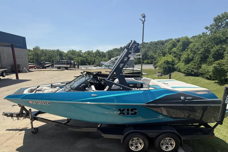 Slide: The Image of 2016 Axis A22 boat in vibrant blue, parked outdoors on a sunny day. - 5