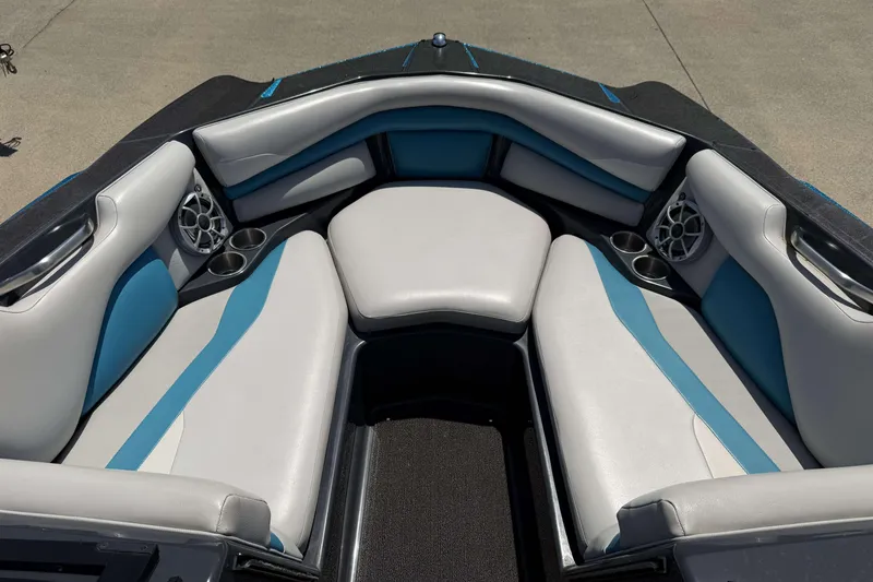 Slide: The Image of 2016 Axis A22 boat interior with blue and white seating, cup holders, and speakers. - 7