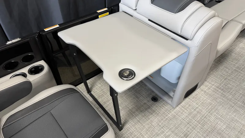 Slide: The Image of A sleek folding table in a modern boat with gray upholstery and cup holders. - 35