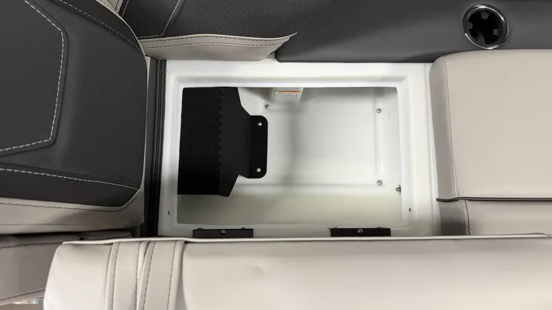 Slide: The Image of An open storage compartment in a 2027 Barletta CABRIO24QC boat, surrounded by cushioned seating. - 31