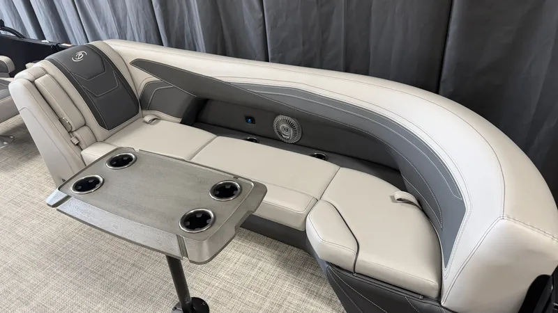 Slide: The Image of The 2027 Barletta CABRIO24QC features a sleek, gray seating area with an integrated table and cup holders. - 23