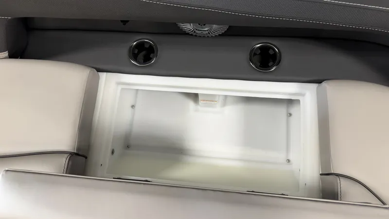 Slide: The Image of An open storage compartment in a 2027 Barletta CABRIO24QC boat, surrounded by cushioned seating. - 28