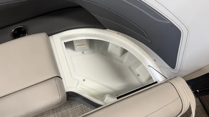 Slide: The Image of An open storage compartment on a Barletta CABRIO24QC boat with cushioned seating and carpeted flooring. - 25