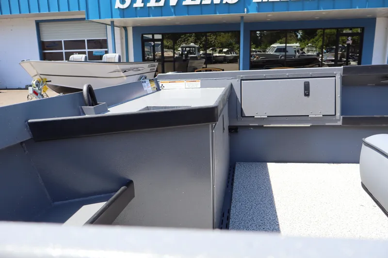 Slide: The Image of 2026 Alumaweld Super Vee Pro 21 boat interior at dealership, showcasing storage and seating. - 8