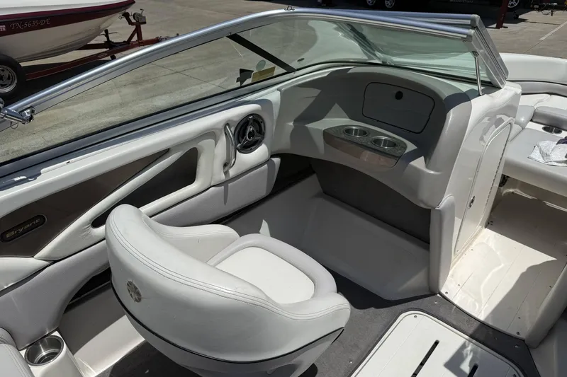 Slide: The Image of Interior of a 2010 Bryant 233 boat with white seating and cup holders. - 12