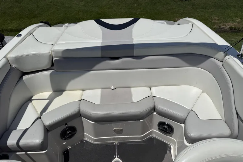 Slide: The Image of 2010 Bryant 233 boat interior with white and gray cushioned seating. - 15