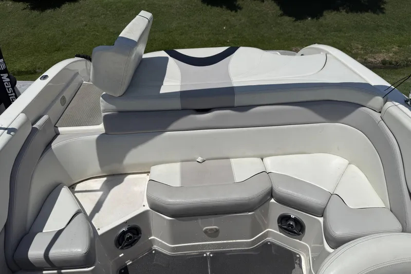 Slide: The Image of Interior seating of a 2010 Bryant 233 boat, featuring white and gray upholstery. - 16