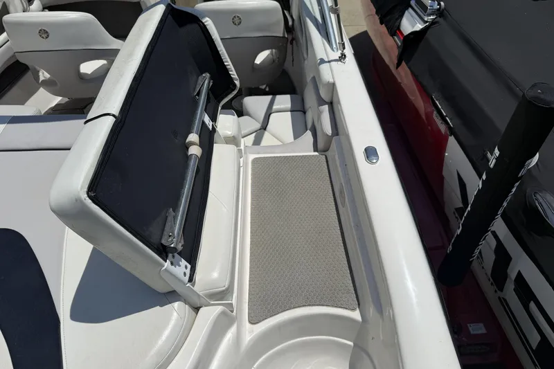 Slide: The Image of 2010 Bryant 233 boat interior with open storage compartment and seating area. - 19