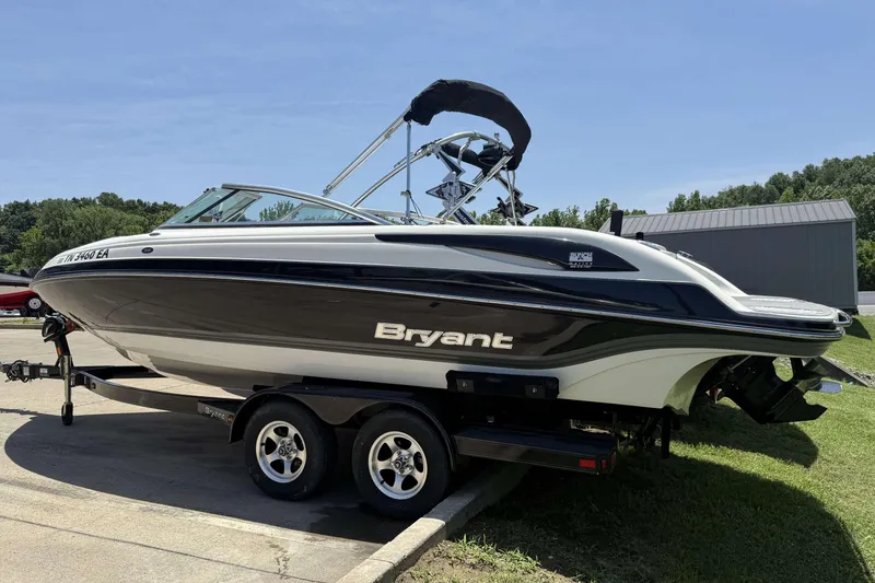 Slide: The Image of 2010 Bryant 233 boat on trailer, black and white design, parked outdoors. - 2