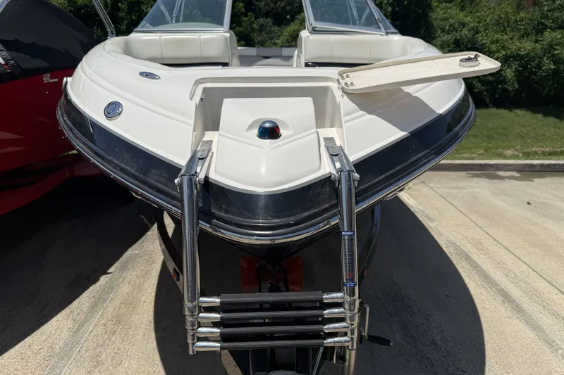 Slide: The Image of 2010 Bryant 233 boat with ladder and open hatch, parked outdoors. - 3