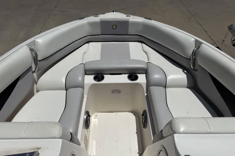 Slide: The Image of Interior of a 2010 Bryant 233 boat with white cushioned seating and cup holders. - 6