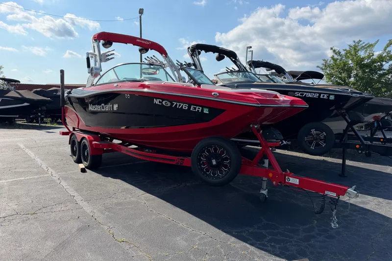 The Image of 2021 Masercraft XT22 boat on trailer in outdoor lot under blue sky. - 1