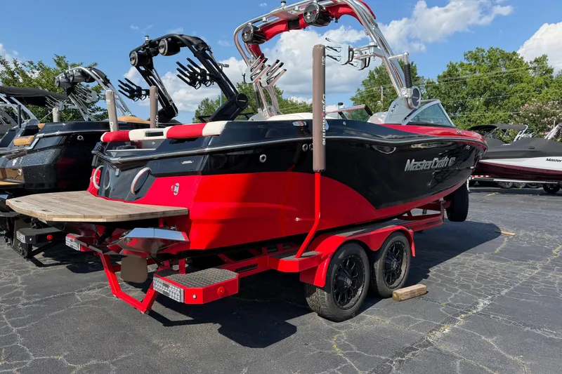 Slide: The Image of 2021 Masercraft XT22 boat in red and black on a trailer, parked outdoors. - 3