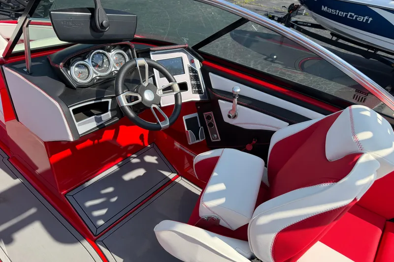 Slide: The Image of 2021 Masercraft XT22 boat interior with red and white seating, modern dashboard, and steering wheel. - 9