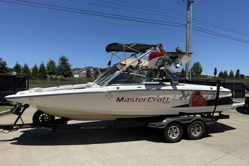 Slide: The Image of 2008 MasterCraft X-45 boat on trailer, parked outdoors under clear blue sky. - 1