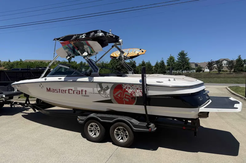 Slide: The Image of 2008 MasterCraft X-45 boat on trailer, featuring wakeboard tower and vibrant graphics. - 2